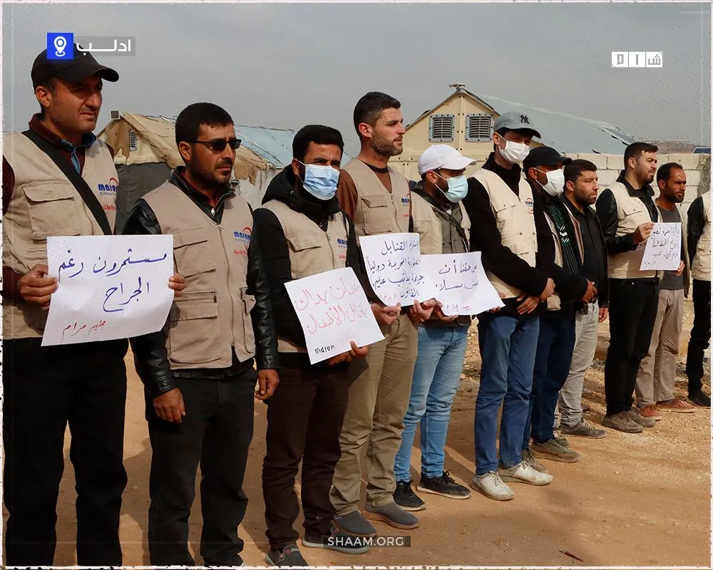 وقفة احتجاجية لموظفي المنظمات الإنسانية والنازحين في مخيم مرام الواقع شمال غرب #إدلب تنديداً بالمجزرة