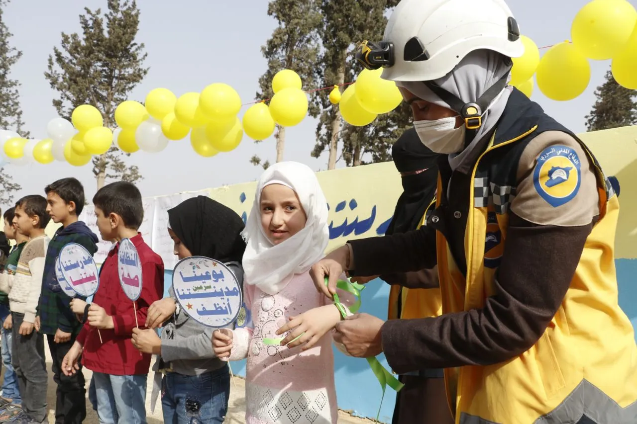 أطفال مع متطوعة من الدفاع المدني السوري