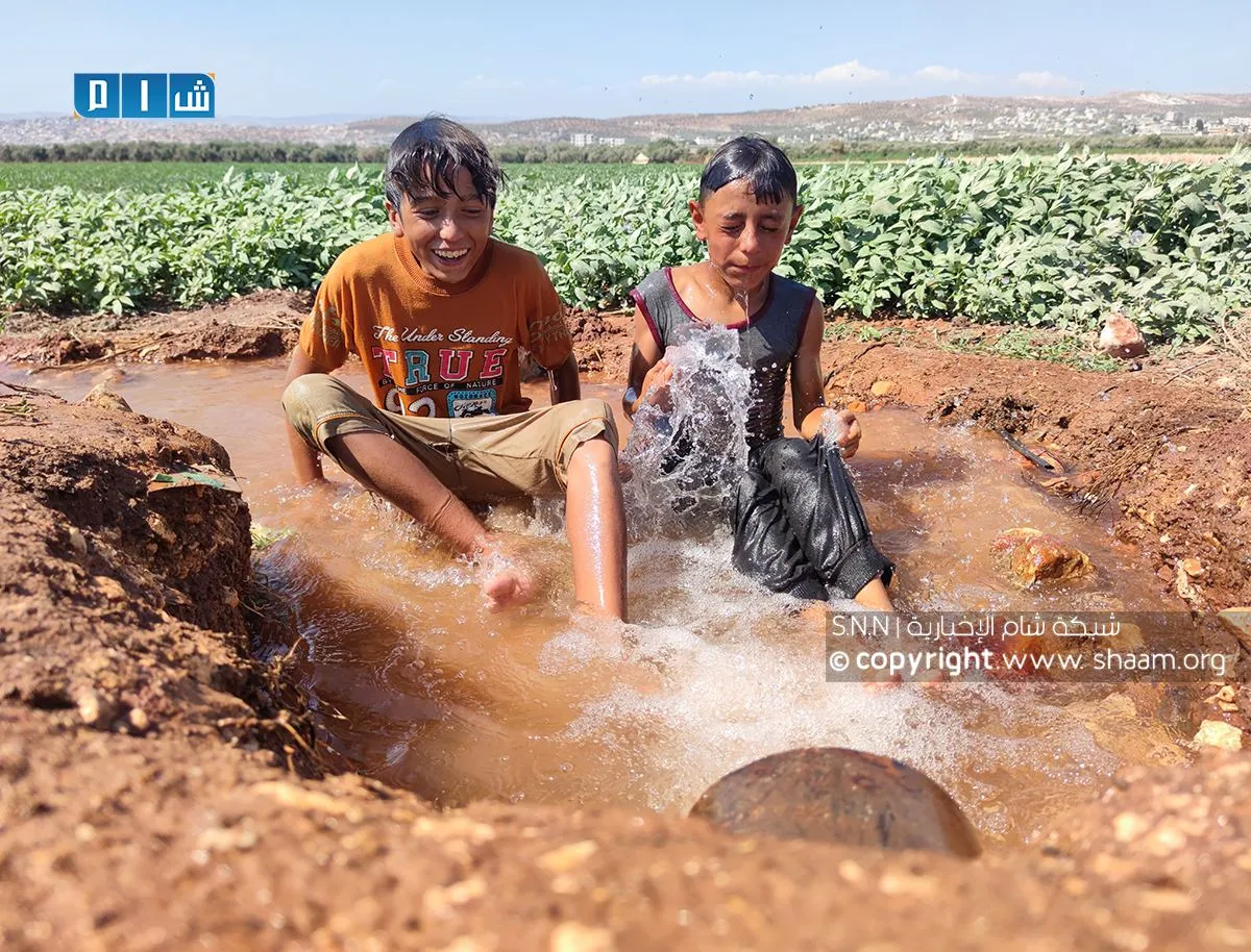 أطفال يلعبون بالماء في موجة الحر الشديدة بريف ادلب (ارشيفية)