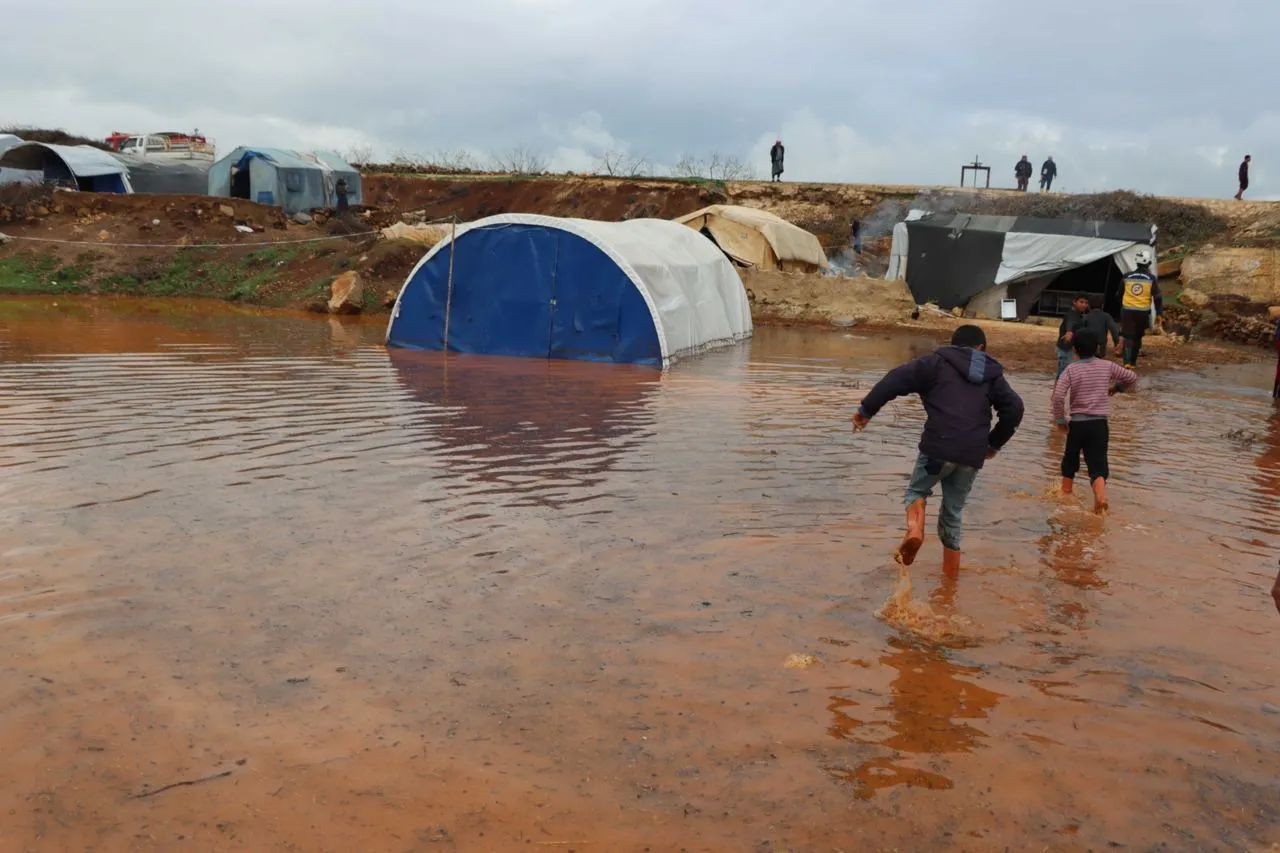 أطفال في أحد مخيمات الشمال السوري في ظل العاصفة المطرية