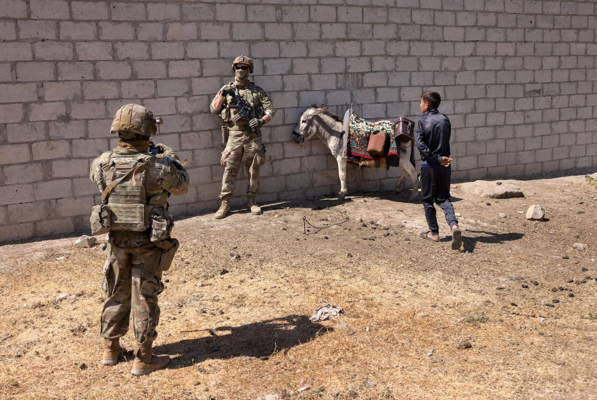 جندي من الجيش الأمريكي يلتقط صورة مع حمار شمال سوريا