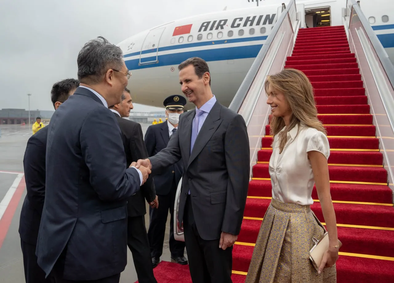 المجرم بشار الاسد وشريكته أسماء خلال استقبالهم من موظفي المطار في الصين
