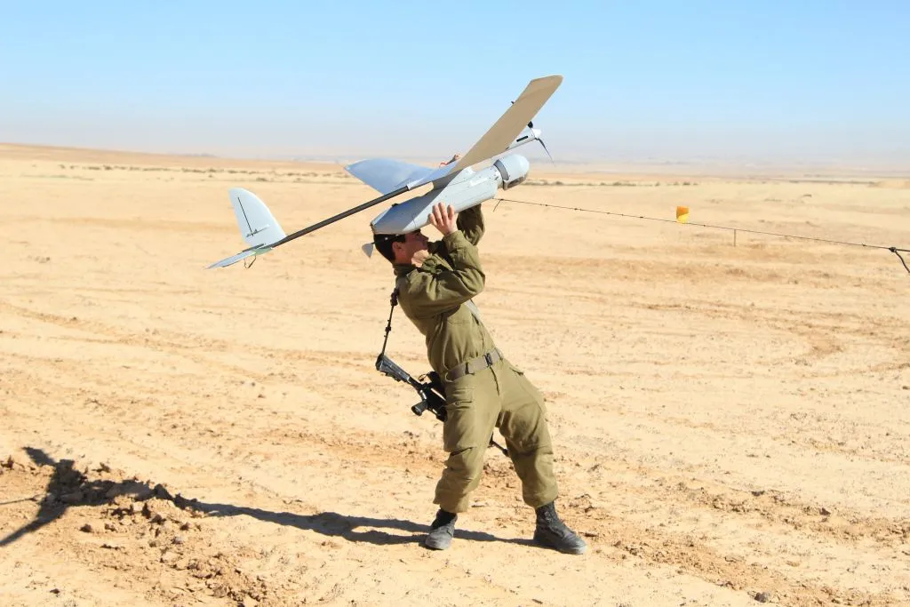 جندي اسرائيلي يحمل طائرة مسيرة من طراز "سكاي رايدر" في الاستعداد لإقلاعها