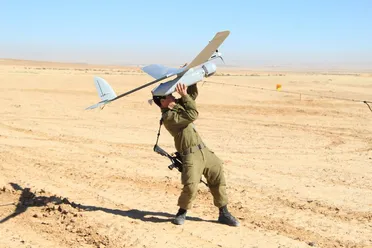 جندي اسرائيلي يحمل طائرة مسيرة من طراز "سكاي رايدر" في الاستعداد لإقلاعها