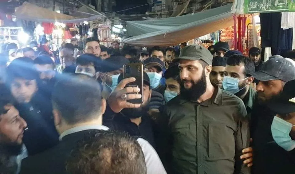حوله مئات الأمنيين بمسرحية مفضوحة .. "الجو.لاني" يتجول في سوق إدلب ليلة عيد الفطر