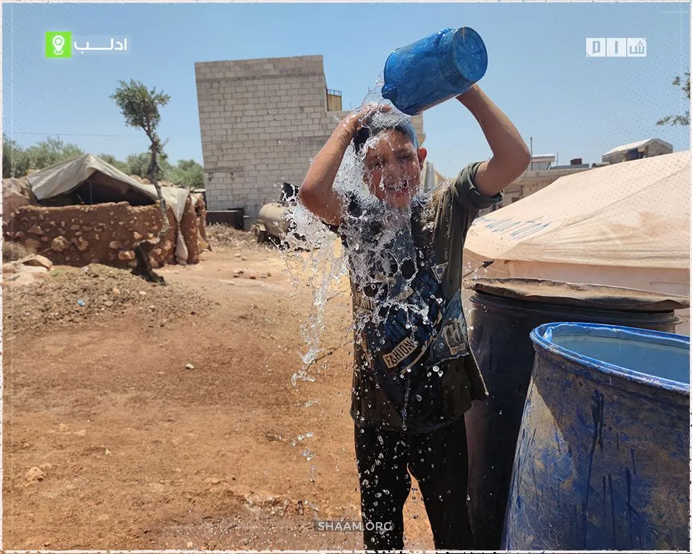 موجة حر تطال النازحين شمال إدلب وأهل الخيام يواجهونها بالماء
